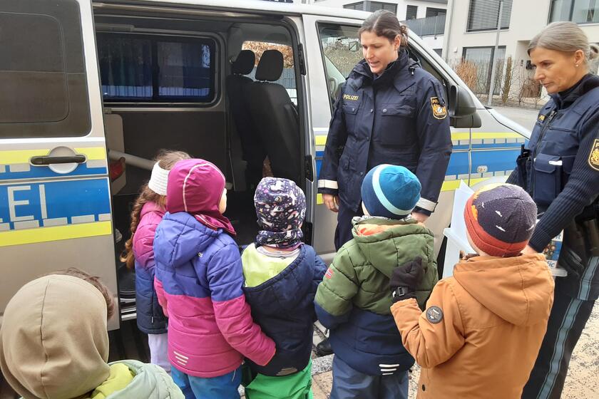 Die Kinder hören den zwei Polizistinnen gespannt zu