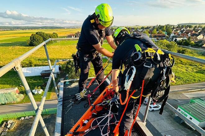 Höhenretter sind in Aktion und befestigen eine Trage um eine Person abzuseilen