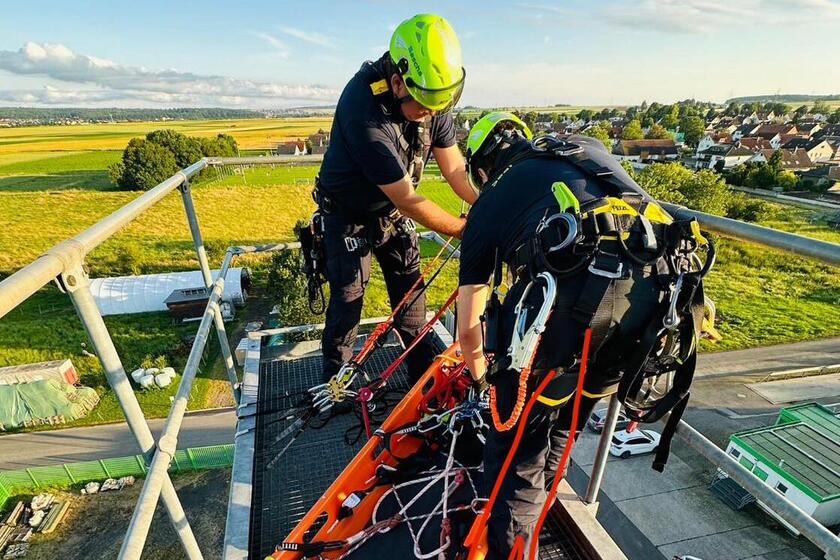 Höhenretter sind in Aktion und befestigen eine Trage um eine Person abzuseilen