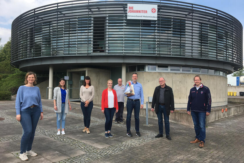 Sebastian Multhoff und einige seiner Mitarbeitenden sowie der ehrenamtliche Regionalvorstand Jörg Dodenhöft vor der Dienststelle der Johanniter in Holzminden.
