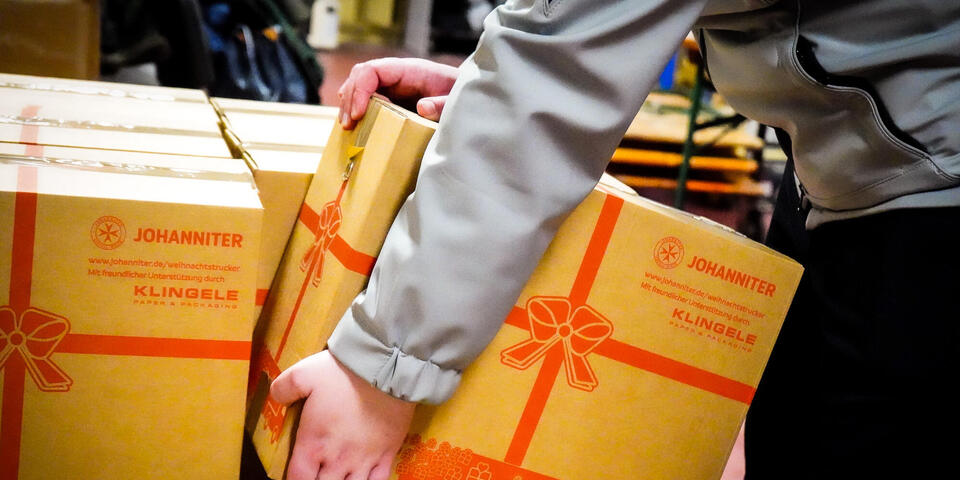 Hände greifen ein Weihnachtstrucker-Paket