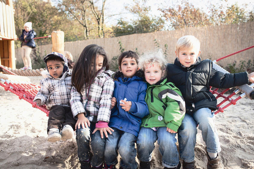 5 Kinder auf einem Seil sitzend