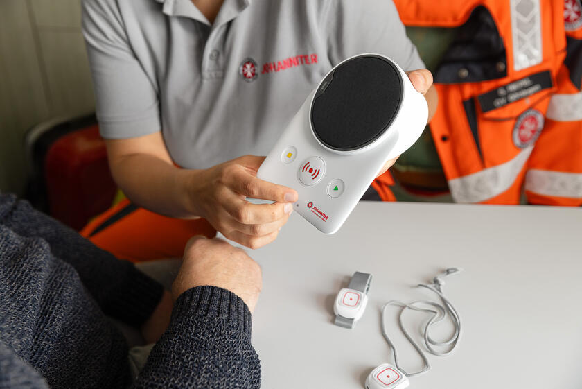 Das Hausnotruf-Gerät wird dem Kunden gezeigt.