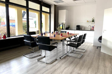 Der Begegnungsraum in Liederbach mit einem großen Tisch und Stühlen für kleinere Gruppen.