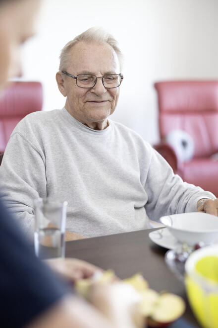 Hospizgast sitzt am Tisch