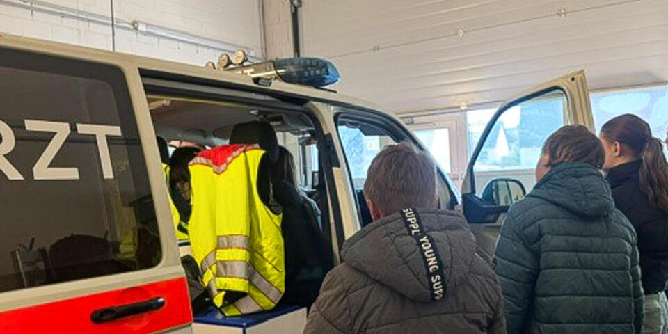 Kinder schauen sich ein Notarzteinsatzfahrzeug an