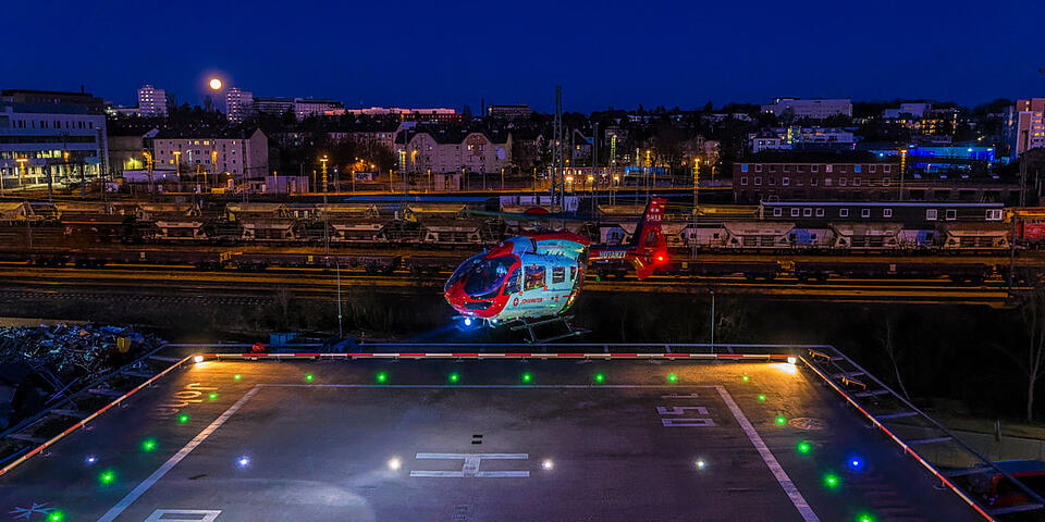 Nachtaufnahme Hubschrauber H145 Christoph Gießen im Landeanflug über Landeplatz.