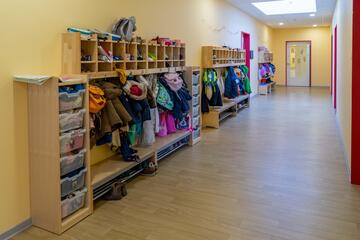 Auf dem Flur der Johanniter-Kita Rellingen stehen Regale, Kleiderhaken und Bänke für die persönlichen Sachen der Kinder.
