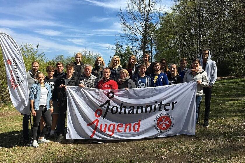 Ein Gruppenbild von Jugendlichen mit einem Johanniter-Jugend-Banner vor der Gruppe