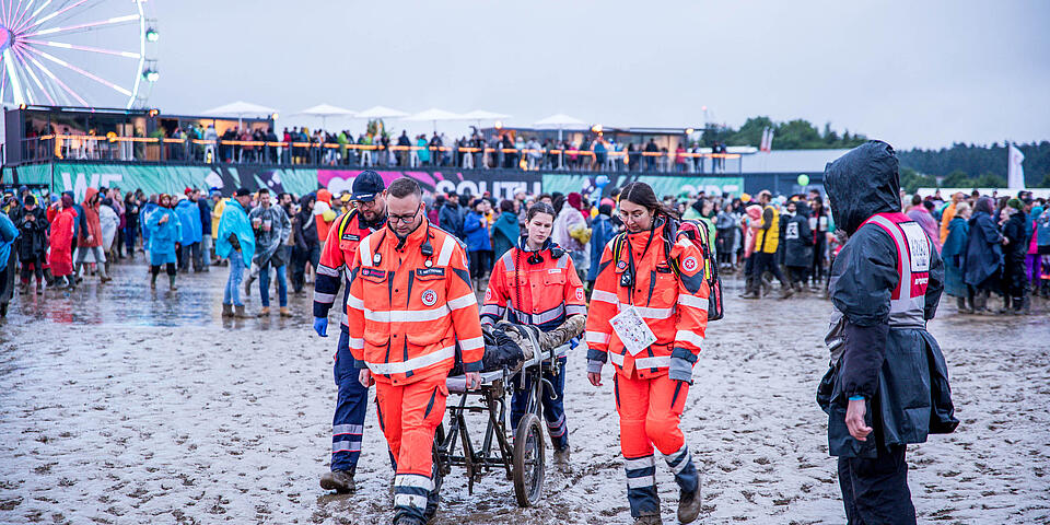 Helfer bringen verletzten Festivalbesucher mit einer Trage in Sicherheit