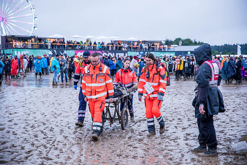 Helfer bringen verletzten Festivalbesucher mit einer Trage in Sicherheit