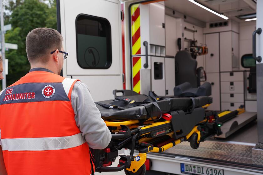 Notfallsanitäter schiebt die Trage in den RTW