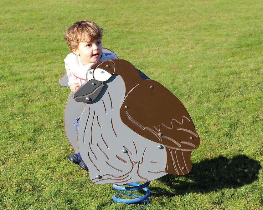 Kleiner Junge auf einer Wippe, die wie ein Vogel aussieht 