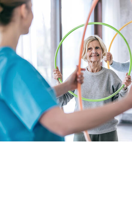 Eine ältere Frau macht Reha-Übungen.
