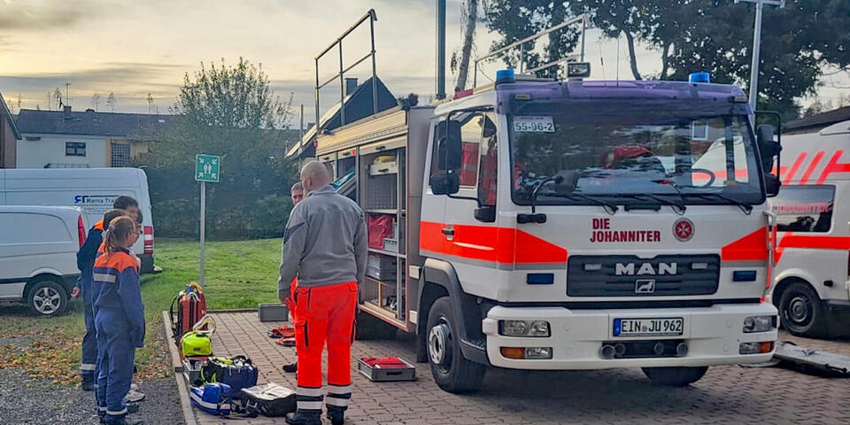 kinder schauen sich den gerätewagen Sanität an