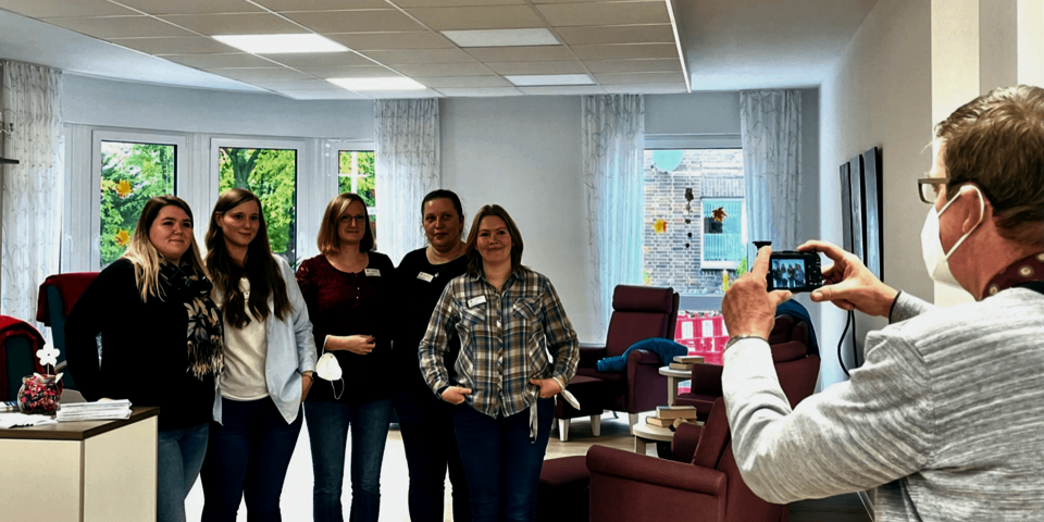 Fünf Frauen werden von einem Mann fotografiert.