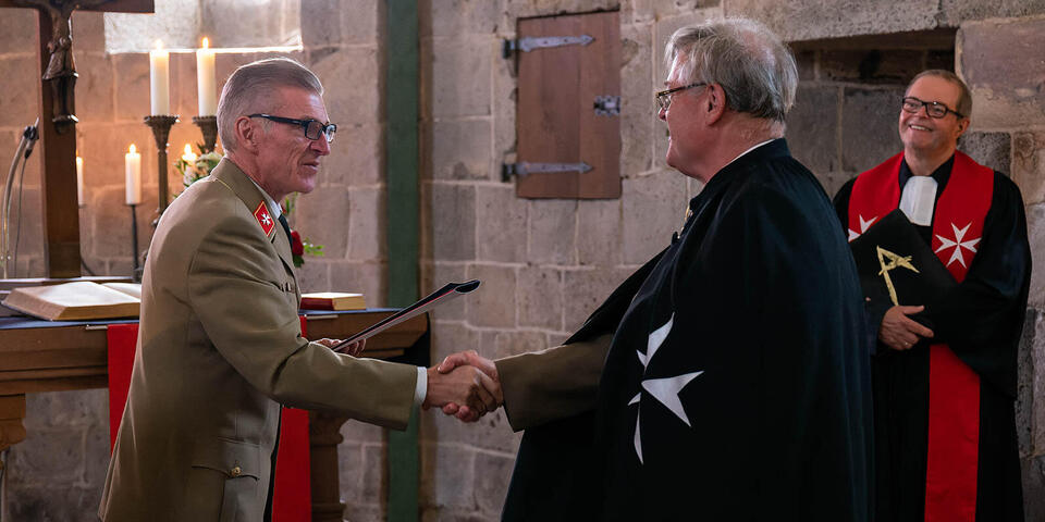 JUH Bundesvorstand Thomas Mähnert begrüßt das neue Landesvorstandsmitglied von Rabenau mit Handschlag.