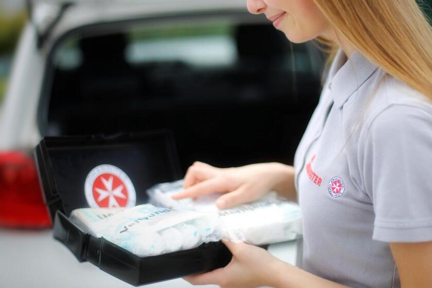 Frau kontrolliert den Inhalt ihre Auto-Verbandskasten