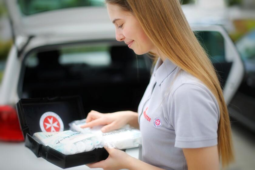 Frau kontrolliert den Inhalt ihre Auto-Verbandskasten