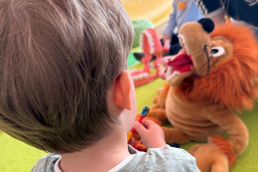 Kind putzt Kuscheltierlöwe die Zähne