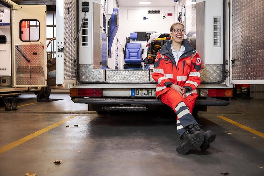 Eine Notfallsanitäterin sitzt im offenen Rettungswagen.