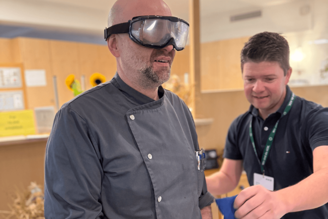 Ein Mann trägt eine klobige Brille mt milchigen Gläsern