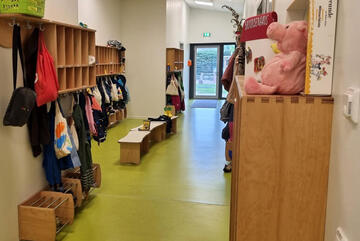 Regale und Garderoben für die Kinder in einem langen Flur.