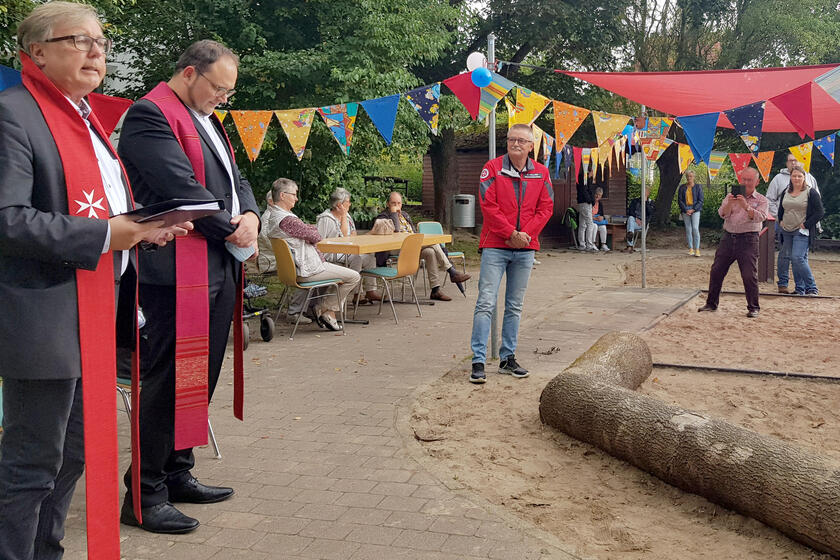 Zwei Pastoren segnen in Anwesenheit von Gästen den Spielplatz