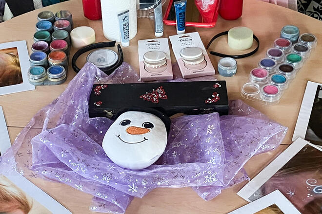 Ein Tisch mit Kinderschminke in der Mitte ein Schneemannkopf
