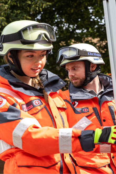 Zwei Ehrenamtliche in Schutzausrüstung