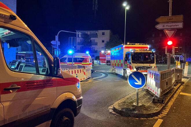 Einsatzfahrzeuge der Johanniter-Unfall-Hilfe und anderer Rettungsdienste stehen nachts mit eingeschaltetem Blaulicht an einer Kreuzung in Nürnberg. Im Vordergrund ist ein Johanniter-Fahrzeug zu sehen, im Hintergrund ein Einsatzleitwagen mit der Aufschrift „Einsatzleitung“ sowie weitere Rettungswagen und Absperrungen.