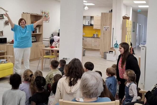 Eine Mitarbeiterin des Seniorenheims begrüßt die Kindergruppe.