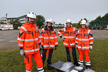 Vier Mitglieder einer Rettungshundestaffel stehen gemeinsam auf dem Wettkampfgelände.
