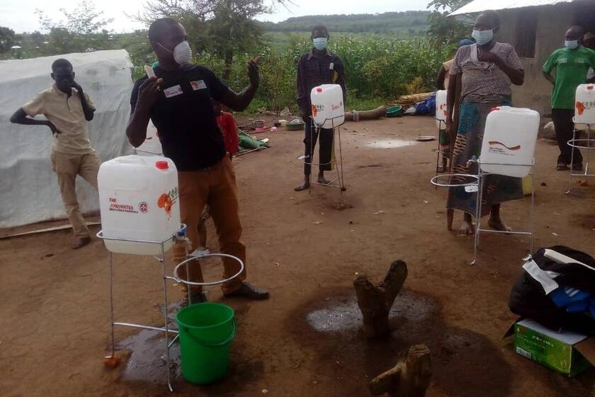 Gemeindebasierte Helferinnen und Helfer machen auf die Bedeutung des Händewaschens gegen Corona in Trainings aufmerksam