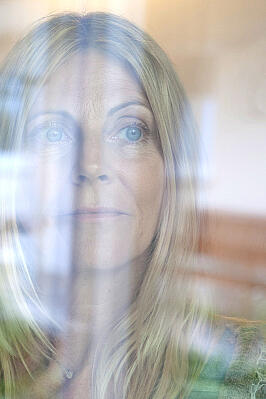 Frau hinter einer Glasscheibe