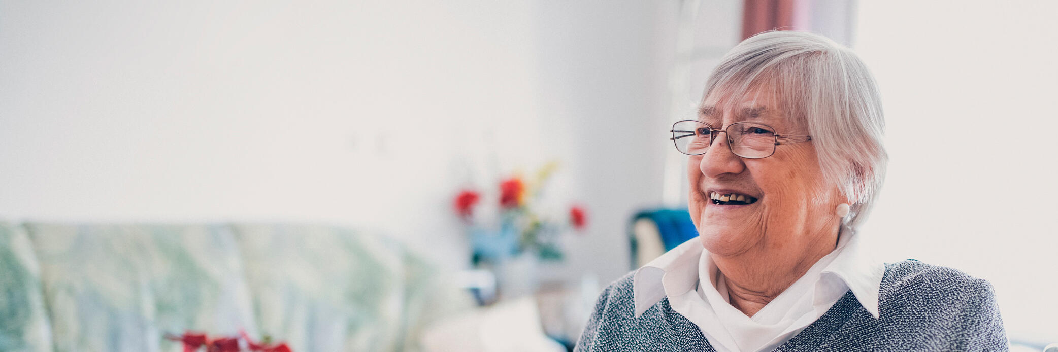 Bewohnerin mit Strickzeug vor einem Wohnzimmertisch