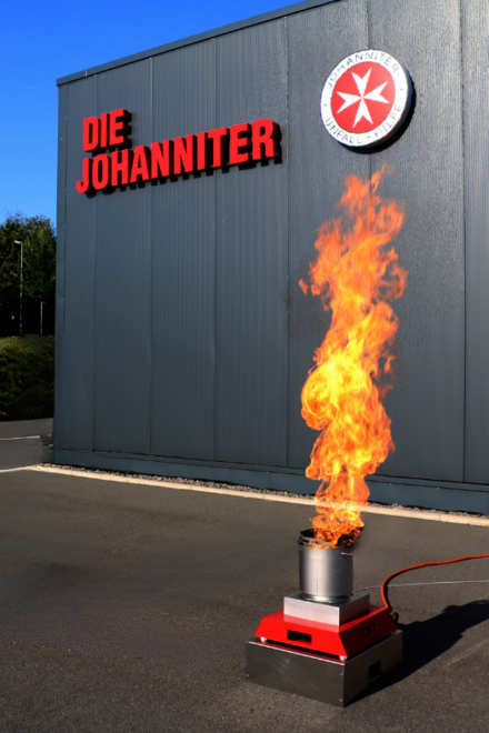 Ein kontrolliertes Feuer im Rahmen einer Ausbildungssituation zum Brandschutzhelfenden. Die Feueranlage steht unter freiem Himmel vor der Regionalgeschäftsstelle der Johanniter Lippe-Höxter in Blomberg. 