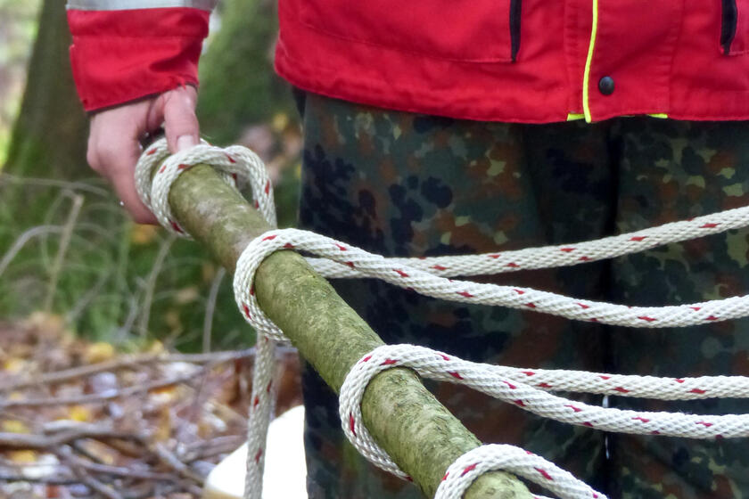 Aus einem Ast und Seilen gebaute Trage