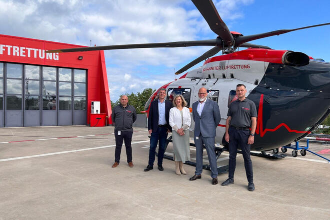 Landrätin Anita Schneider aus dem Landkreis Gießen und der Solmser Bürgermeister Frank Inderhalvor einem Hubschrauber der JLR zusammen mit Geschäftsführer Frank Zabell.
