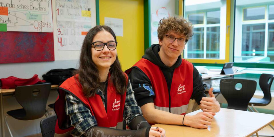 Zwei Schulsanitäter der Johanniter in Taunusstein sitzen an einem Tisch.