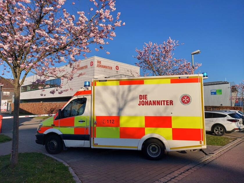 Ein RTW steht vor einer Schranke.  Im Hintergrund sieht man die Memminger Johanniter-Rettungswache.