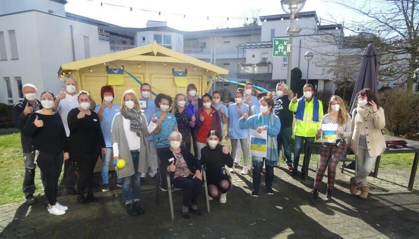 Ein Guppenfoto von Menschen mit Masken, die den Daumen in die Höhe strecken 