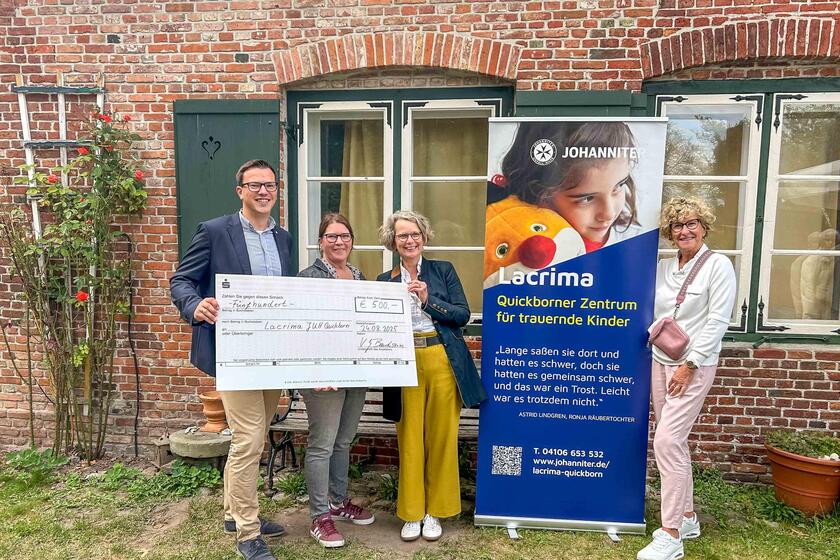 Mitarbeitende der Johanniter sowie der Johanniter-Hilfsgemeinschaften halten einen Spendenscheck in der Hand.