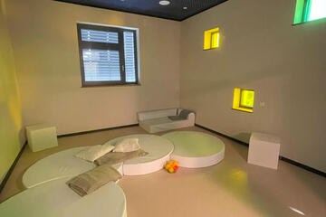 Ein gemütlicher abgedunkelter Raum mit Liegemöglichkeiten.