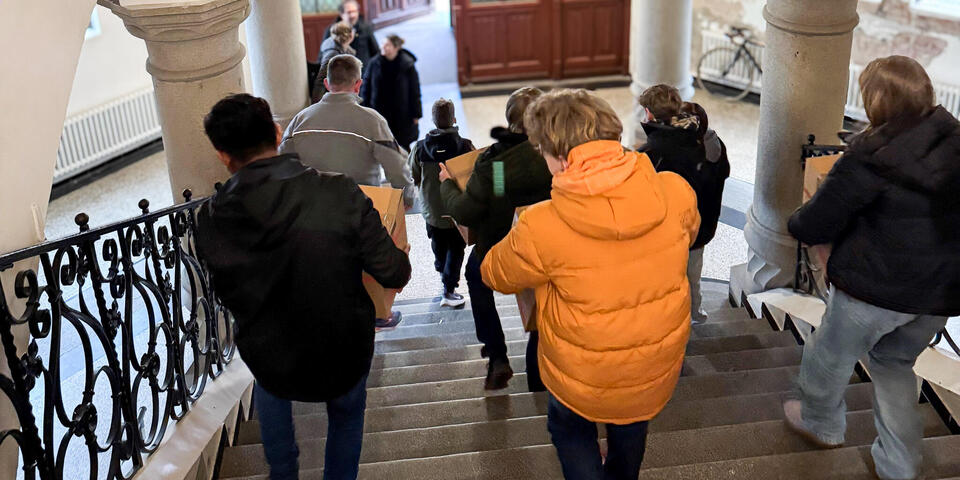 Kinder tragen Pakete eine Treppe runter