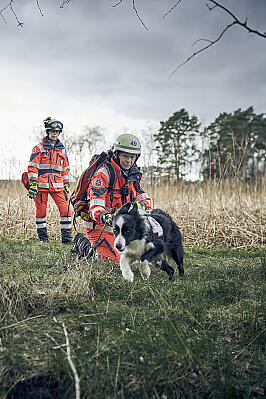 Zwei Frauen mit Einsatzkleidung und ein Hund im Gelände