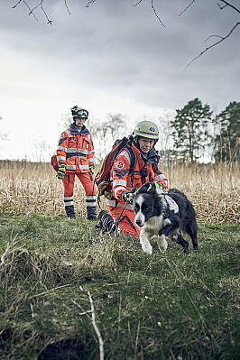 Zwei Frauen mit Einsatzkleidung und ein Hund im Gelände