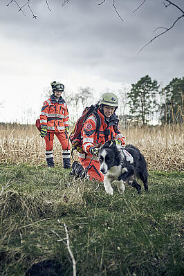 Zwei Frauen mit Einsatzkleidung und ein Hund im Gelände