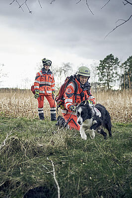 Zwei Frauen mit Einsatzkleidung und ein Hund im Gelände