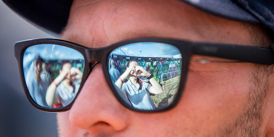 In der Sonnenbrille eines Helfers ist die Reflektion des Fotografen zu sehen